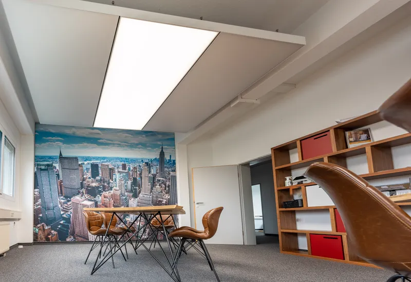 Besprechungsraum mit NYC-Wandbild und interpanel Klimaleuchten zur Deckenkühlung