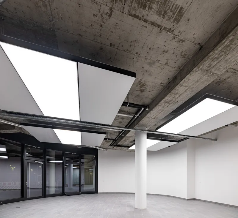 Sichtbetondecke mit interpanel Klimaleuchten — taupunktunabhängige Deckenkühlung im Bürogebäude Berlin