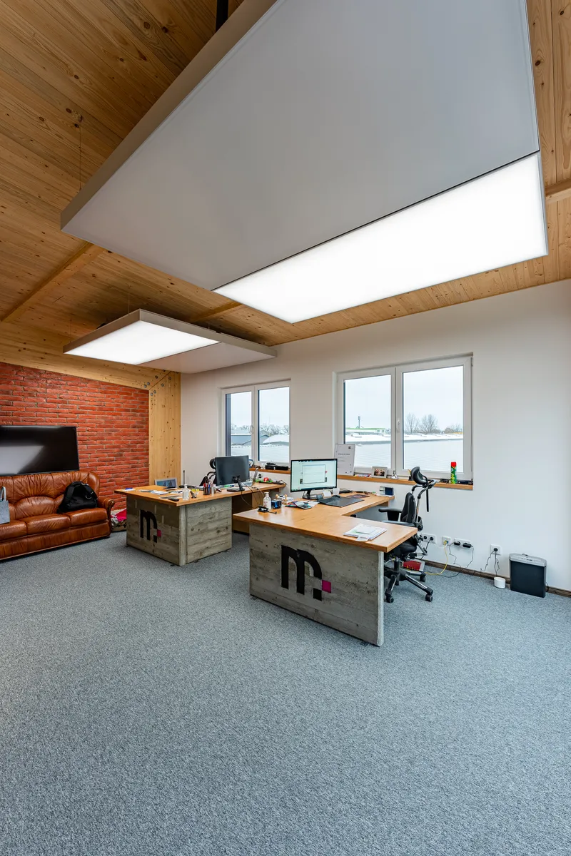 Großraumbüro mit mehreren interpanel Klimaleuchten und Backsteinwand