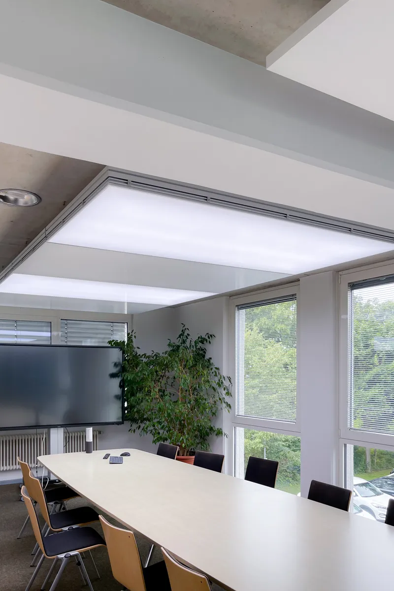 Konferenzraum mit interpanel Klimaleuchte und großem Besprechungstisch