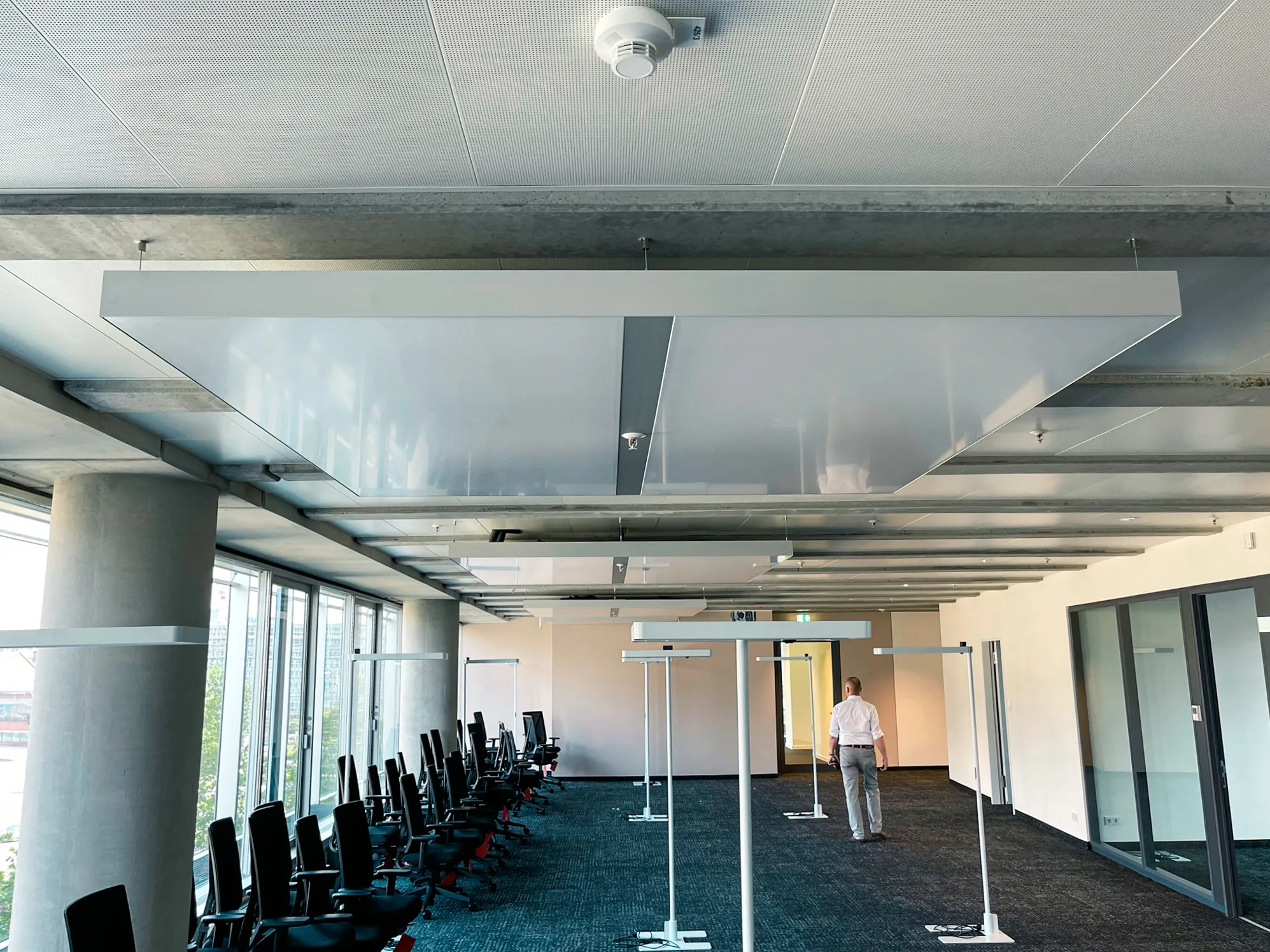 Großraumbüro im Deichtor Office Center Hamburg mit interpanel Klimaleuchten, Glasfassade und Betonstützen