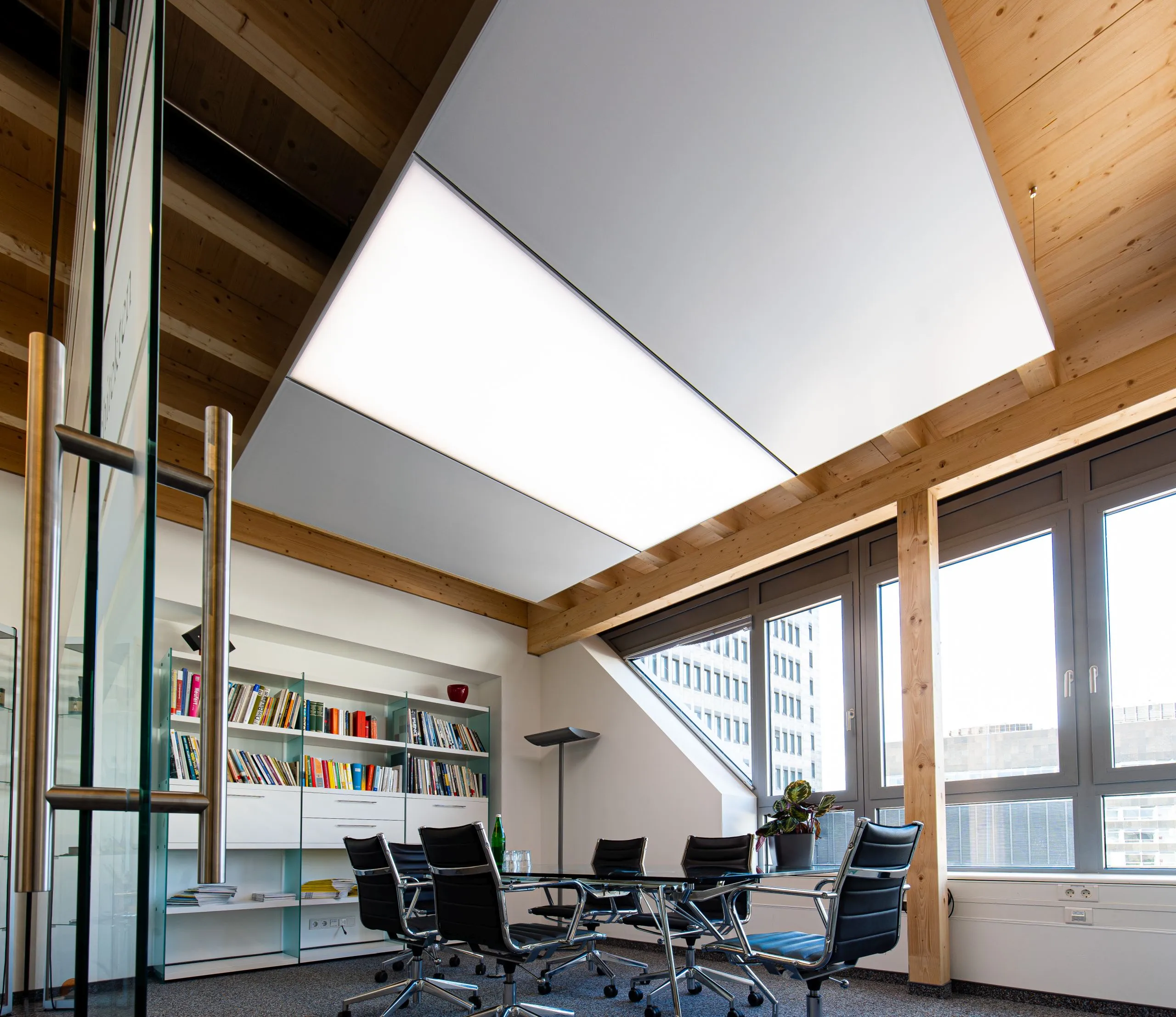 Konferenzraum mit interpanel Klimaleuchten unter Holzdachkonstruktion bei ABW Architekten Düsseldorf